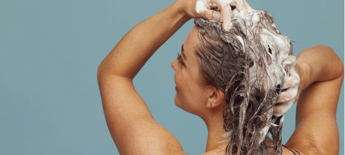Mujer lav&aacute;ndose el pelo
